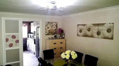 a dining room with a table and flowers on the wall at Double room in riverside apartment - B in Glasgow