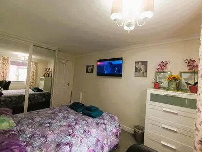 a bedroom with a bed and a tv on the wall at Double room in riverside apartment - B in Glasgow