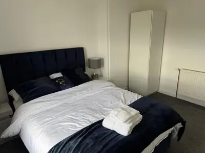 a bedroom with a bed with towels on it at Chic & Cozy 2BR Semi-Detached in Kilmarnock