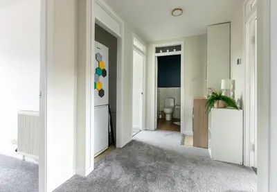 a white hallway with a bathroom with a toilet at John Neilson View - Coorie Doon in Paisley
