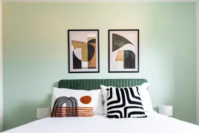 a bedroom with a bed with three pictures on the wall at John Neilson View - Coorie Doon in Paisley