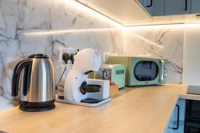 a kitchen counter with a coffee maker and a microwave at John Neilson View - Coorie Doon in Paisley