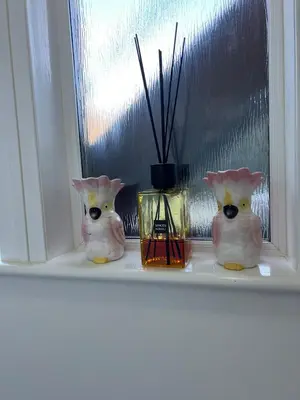 three ceramic cats sitting on a window sill at Coatbridge central apartment 20 min from Glasgow in Coatbridge
