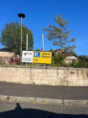 a sign for a barber shop on a brick wall at Coatbridge central apartment 20 min from Glasgow in Coatbridge