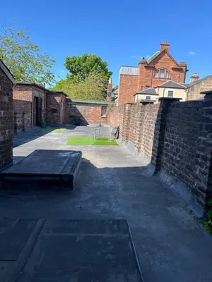 a brick wall with a bench next to a building at Coatbridge central apartment 20 min from Glasgow in Coatbridge