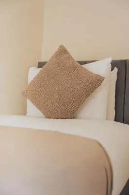 a white bed with a pillow on top of it at Stylish 3BR Home near Hampden No 264 with Free Parking in Glasgow