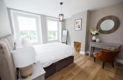 a bedroom with a bed and a desk and a mirror at Stylish 3-Bed Apartment in the Heritage Quarter in Dunfermline
