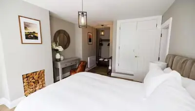 a bedroom with a white bed and a fireplace at Stylish 3-Bed Apartment in the Heritage Quarter in Dunfermline