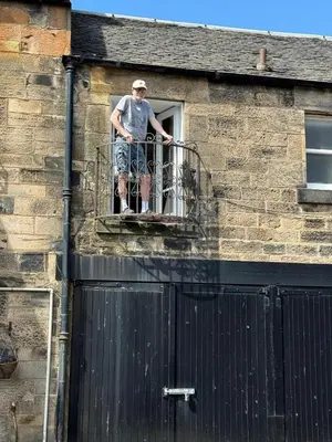 a man standing on a balcony on a building at Truly Central, Princes St, close to Castle in Edinburgh