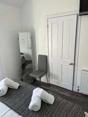 a bedroom with two towels on a bed and a chair at Truly Central, Princes St, close to Castle in Edinburgh