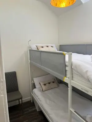 a bedroom with two bunk beds and a chair at Truly Central, Princes St, close to Castle in Edinburgh