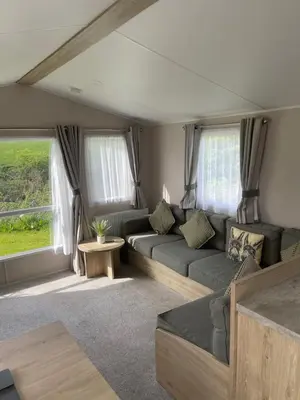 a living room with a couch and a table at One Muirfield, Caravan at Turnberry in Turnberry