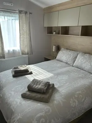 a bedroom with a bed with two towels on it at One Muirfield, Caravan at Turnberry in Turnberry