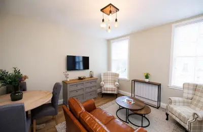 a living room with a couch and a table at Stylish 1-Bed Apartment in the Heritage Quarter in Dunfermline