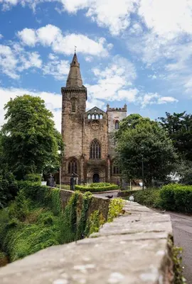an old stone building with a tower on a street at Stylish 1-Bed Apartment in the Heritage Quarter in Dunfermline