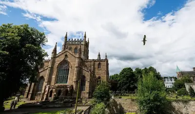 an old church with a bird flying in the sky at Cosy Apartment in the Heritage Quarter - Sleeps 2 in Dunfermline