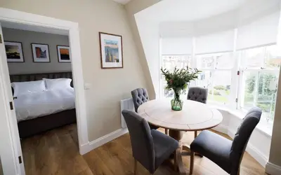 a room with a table and chairs and a bed at Cosy Apartment in the Heritage Quarter - Sleeps 2 in Dunfermline