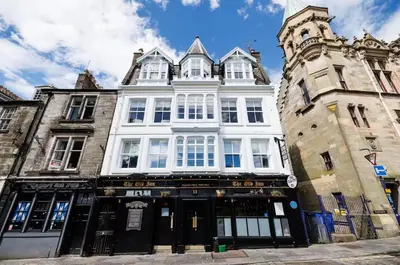 a large white building on the corner of a street at Stylish 2-Bed Apartment in the Heritage Quarter in Dunfermline