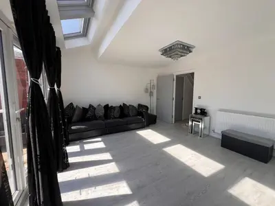 a living room with a black couch and a window at Z&Z Villa in Moffat