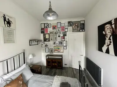 a bedroom with a bed and a wall of pictures at Rothesay, Isle of Bute in Rothesay