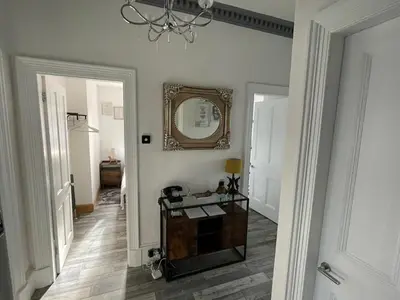 a hallway with a mirror on the wall and a table at Rothesay, Isle of Bute in Rothesay