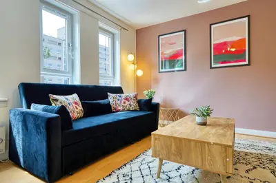 a living room with a blue couch and a coffee table at 2BR Flat Parking Near City and Finnieston in Glasgow