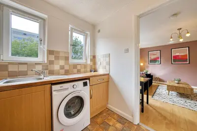 a washing machine in a kitchen with a sink at 2BR Flat Parking Near City and Finnieston in Glasgow