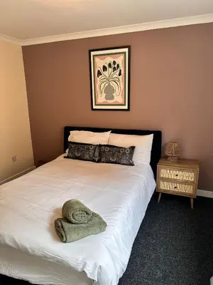 a bedroom with a bed with a towel on it at 3BR Flat Sleeps 6 West End Sights Driveway in Glasgow