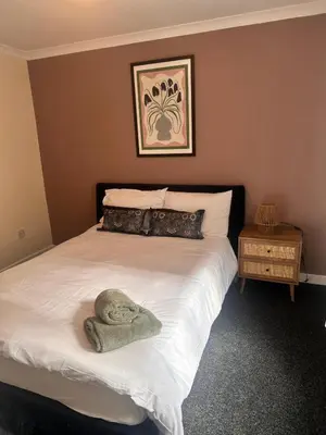 a bedroom with a bed with a towel on it at 3BR Flat Sleeps 6 West End Sights Driveway in Glasgow
