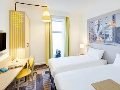 a hotel room with two beds and a desk at ibis Styles Glasgow Centre George Square in Glasgow