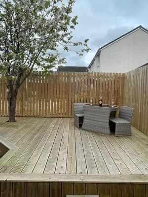 a patio with two chairs and a table and a fence at Modern flat in quiet residential cul-de-sac in Kilwinning