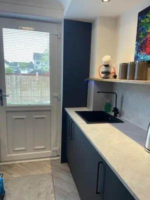 a kitchen with a sink and a door with a window at Modern flat in quiet residential cul-de-sac in Kilwinning