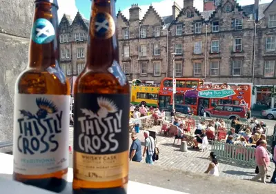 two bottles of beer sitting on a ledge in a city at Grassmarket Old Town Boutique Apartment in Edinburgh