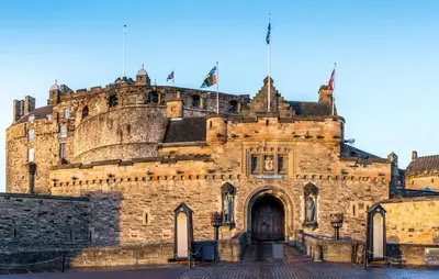 an old stone building with two flags on top at Grassmarket Old Town Boutique Apartment in Edinburgh