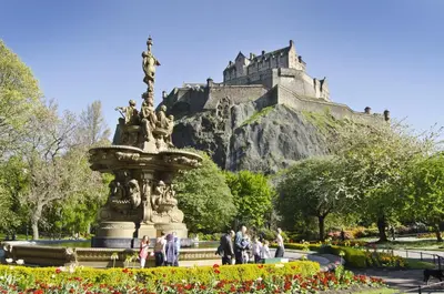 people walking around a fountain in front of a castle at Grassmarket Old Town Boutique Apartment in Edinburgh