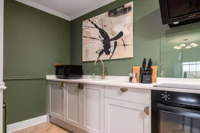 a kitchen with green walls and a white counter top at Emerald Suite, The Stirling Residence in Stirling