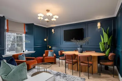 a room with a table and chairs and a tv at Sapphire Suite, The Stirling Residence in Stirling