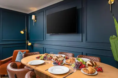 a table with a plate of food on it at Sapphire Suite, The Stirling Residence in Stirling