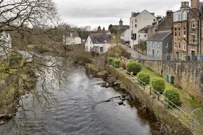 a river in a city with houses and buildings at Bridgend Studio - Near Free Parking in Stirling