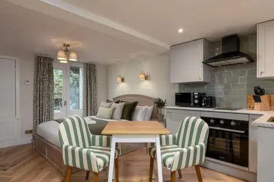 a kitchen and living room with a table and chairs at Bridgend Studio - Near Free Parking in Stirling