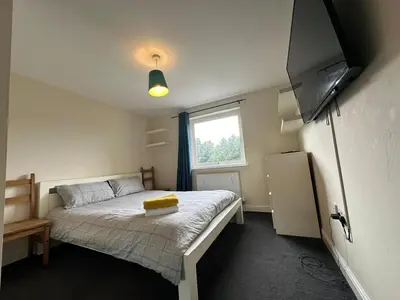 a small bedroom with a bed and a television at 2 Bed & 2 Bath-Flat-Driving Distance to Edinburgh in Uphall