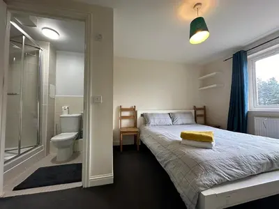 a bedroom with a bed and a shower and a toilet at 2 Bed & 2 Bath-Flat-Driving Distance to Edinburgh in Uphall