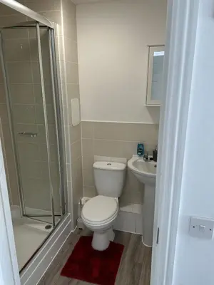 a bathroom with a toilet and a shower and a sink at 2 Bed 2 Bath Flat 27Atholway in Uphall