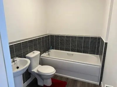 a bathroom with a toilet and a tub and a sink at 2 Bed 2 Bath Flat 27Atholway in Uphall