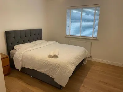 a bedroom with a bed with a pair of shoes on it at 2 Bed 2 Bath Flat 27Atholway in Uphall