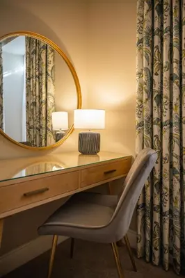 a dressing table with a mirror and a chair at Stirling Townhouse Apartment Btm in Stirling