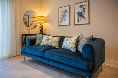 a blue couch in a living room with a lamp at Stirling Townhouse Apartment Btm in Stirling