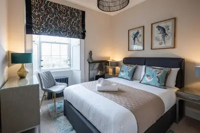 a bedroom with a bed and a desk and a window at Stirling Townhouse Apartment Top in Stirling