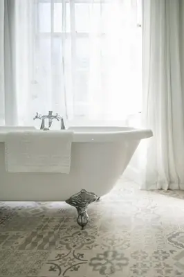 a white bath tub sitting in front of a window at Stirling Townhouse Apartment Top in Stirling