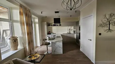 a kitchen with a table in the middle of a room at Harbour Havens Apartments in Moffat